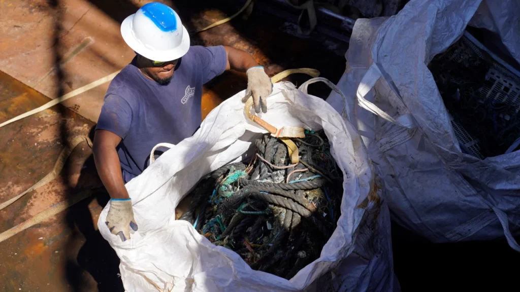 Man standing by a bag of old fishing nets